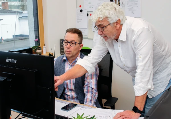 Stefan Neuner und Thomas Kleinsorge beim Planen einer Photovoltaikanlage am Schreibtisch mit Computer